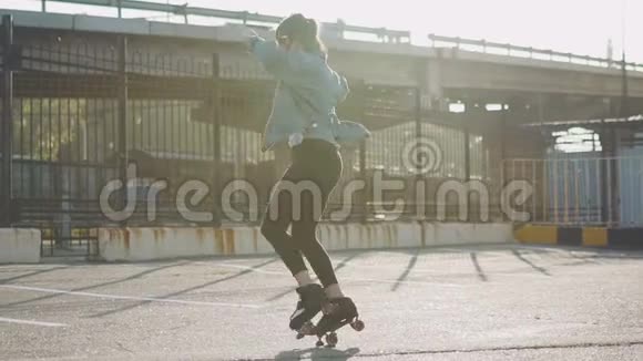 漂亮漂亮的年轻女子骑着轮滑在街上跳舞城市背景慢动作120fps视频的预览图