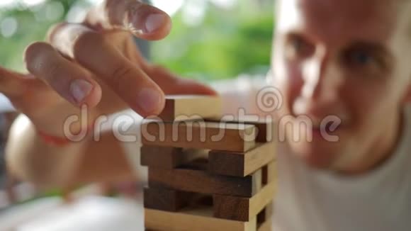 年轻人玩木塔桌游木制的高清慢动作录像泰国视频的预览图