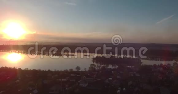 日落时鸟瞰村庄和湖泊4K视频的预览图