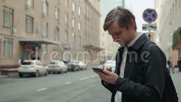 快乐微笑的商人穿着西装清晨在办公室附近使用现代智能手机成功的雇主视频的预览图