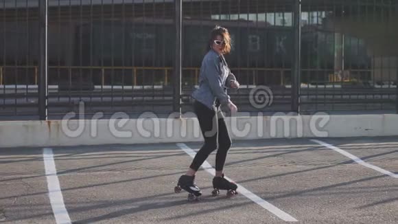 漂亮漂亮的年轻女子骑着轮滑在街上跳舞城市背景慢动作120fps视频的预览图
