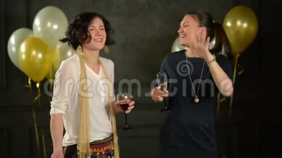 笑的女人喜欢迪斯科舞会跳舞和喝酒两个Brunettes一起拿着眼镜跳舞视频的预览图
