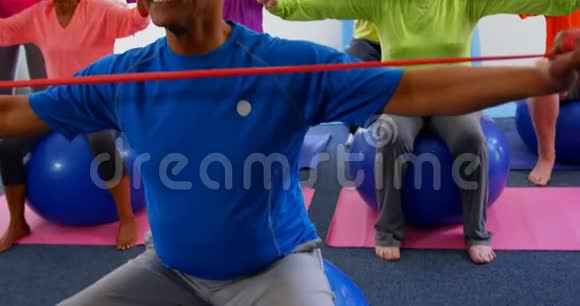 高加索女培训师在4k健身工作室训练老年人锻炼的正面视角视频的预览图