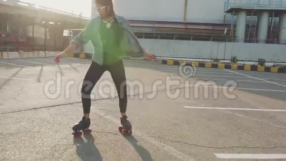 漂亮漂亮的年轻女子骑着轮滑在街上跳舞城市背景4k视频的预览图