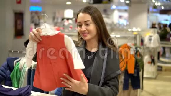 顾客妇女在店里挑选婴儿服装视频的预览图