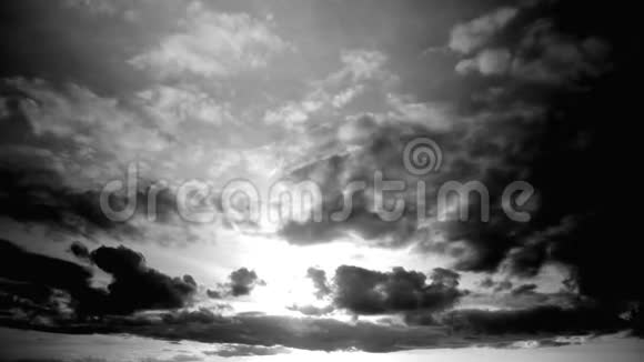 在时间推移中高度对比黑白云景太阳照在云后从左到右移动视频的预览图