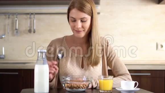 美丽的年轻迷人的女人在厨房吃玉米片作为早餐一杯咖啡视频的预览图