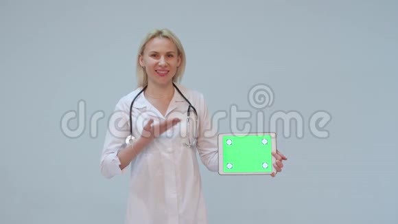 一位身穿白大褂戴着绿屏和听诊器微笑的女医生的画像视频的预览图