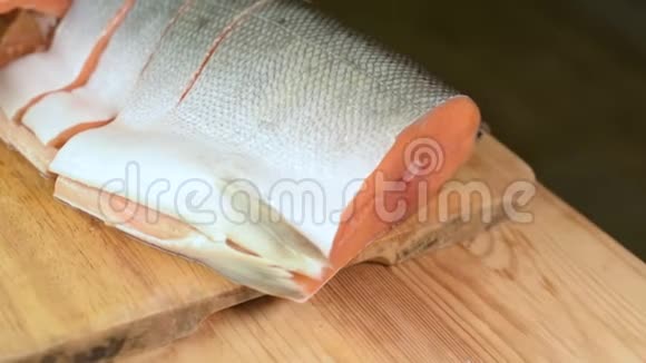 将三文鱼片切成薄片放在木切割板上家庭厨房健康食品视频的预览图