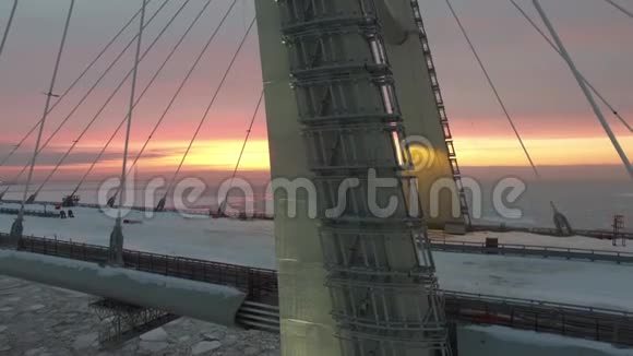 令人惊叹的空中4k观景台巨大的钢桥在建筑工地横跨冰冰湖在温暖的粉红色傍晚日落视频的预览图