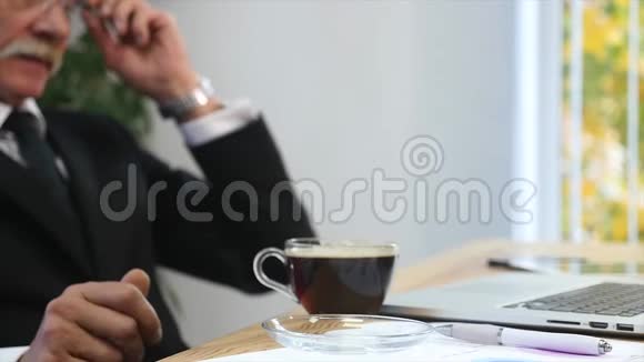 疲惫的商务服务员在办公室里工作喝着咖啡选择性聚焦视频的预览图