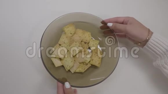 大薯片碗女人吃薯片的手特写女人手扭着一盘薯片视频的预览图