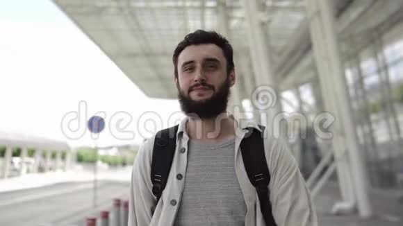 一个满脸胡须的男人拿着背包走路检查他的智能手表视频的预览图
