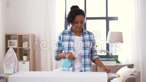 非洲裔美国妇女在家熨烫床单视频的预览图