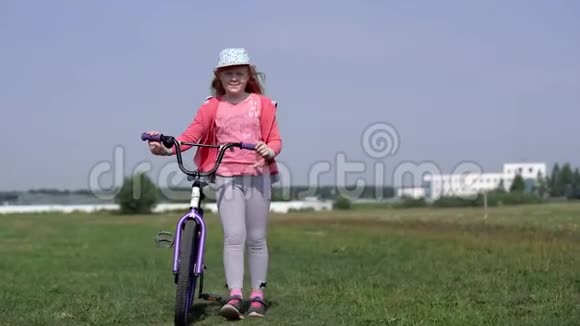 健康的生活方式骑自行车的女孩在城市附近的田野上行走视频的预览图