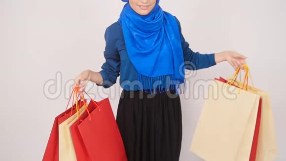 快乐的年轻穆斯林妇女正拿着购物袋视频的预览图