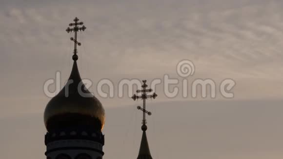 日出天空上金色教堂穹顶的剪影教堂塔顶上的基督教十字架4K视频的预览图