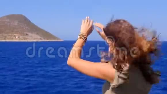 一个年轻的女人从船甲板上欣赏大海视频的预览图