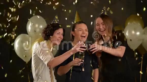 快乐的年轻女人祝她们的朋友在金色的纸屑中生日快乐可爱的女孩在聚会上庆祝视频的预览图