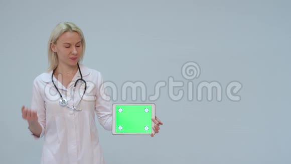 一位身穿白大褂戴着绿屏和听诊器微笑的女医生的画像视频的预览图
