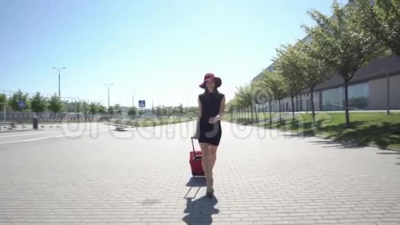 戴红帽子的女人带着红手提箱走在外面视频的预览图