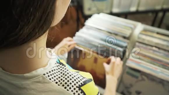 年轻女子在跳蚤市场看旧唱片视频的预览图