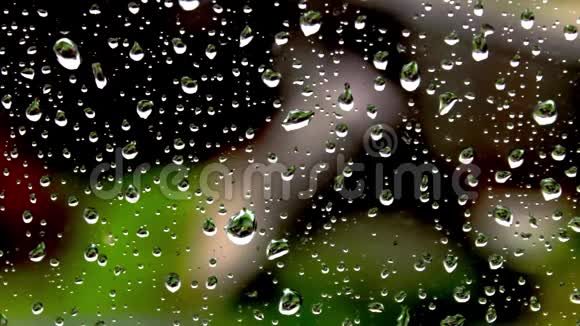 大自然背景下的玻璃上的雨点视频的预览图