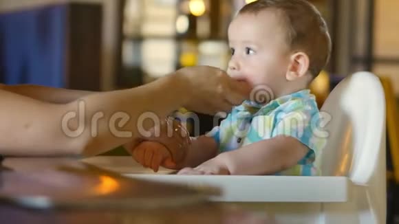 妈妈用嘴和手擦着可爱的宝宝一个迷人的孩子笑着拍手4k视频的预览图
