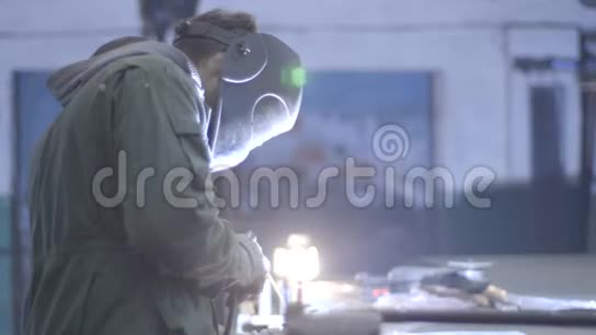 用现代焊机在生产制造中焊接金属结构的防护面罩的工业工人视频的预览图