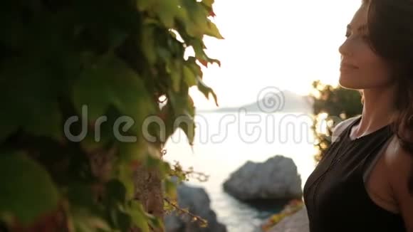 夏季傍晚美丽的黑发女郎在海边户外摆姿势视频的预览图