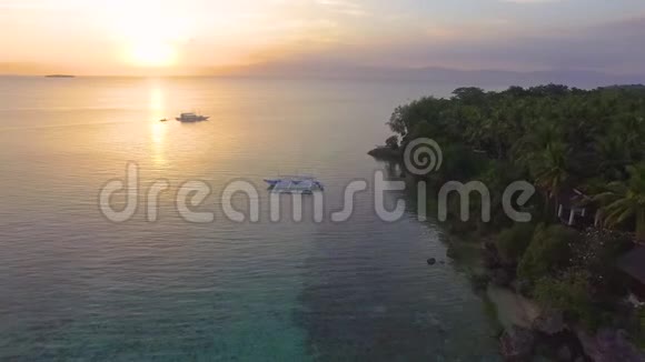 空中美丽的热带海滩日落与木船在距离视频的预览图