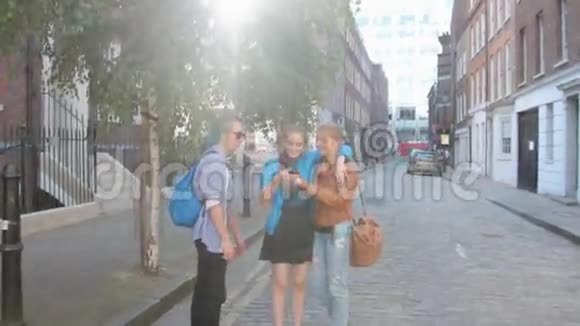 四个朋友正走在伦敦的街道上做自拍笑和开玩笑在暑假视频的预览图