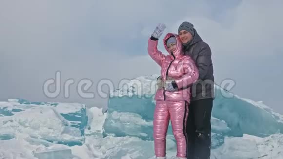 在冰封的湖面上年轻夫妇在冬天散步时玩得很开心情侣们玩得很开心笑了视频的预览图