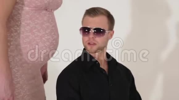 穿西装戴墨镜的帅哥在穿粉色衣服的孕妇旁边唱歌视频的预览图