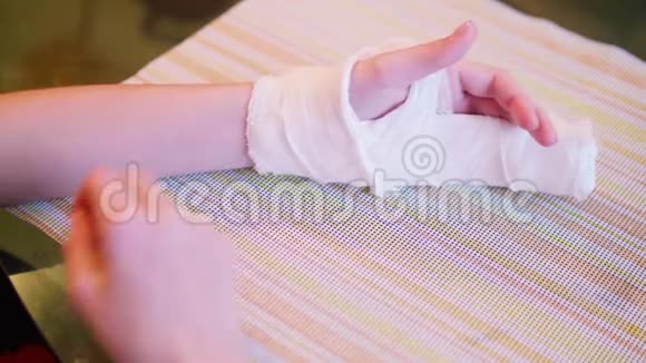 白种人的孩子试图用石膏绷带划伤他的手视频的预览图
