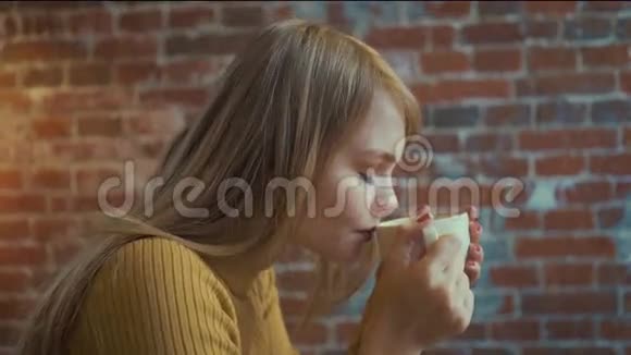 美丽的女孩正享受着咖啡的香气在咖啡馆休息时微笑着视频的预览图