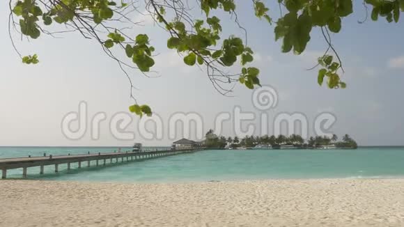 蓝色海洋上的码头通向一个美丽的岛屿有白色的海滩和棕榈树视频的预览图