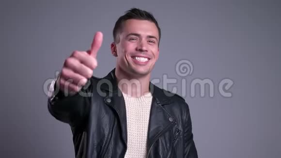 一位英俊的白种人的特写肖像他微笑着看着摄像机竖起大拇指视频的预览图