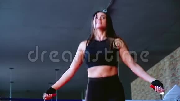 动作慢特写迷人可爱的苗条黑发女子运动员在健身房跳绳训练拳击视频的预览图