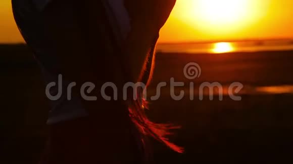 年轻女子在夕阳下祈祷的剪影视频的预览图