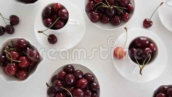白色杯子和碗中生樱桃的俯视图视频的预览图
