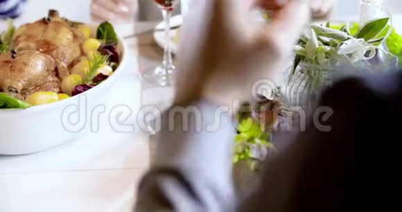 桌子上有鸡肉和土豆的食物细节四个快乐的真正坦率的朋友喜欢一起吃午餐或晚餐视频的预览图