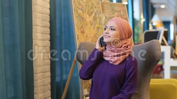 穆斯林妇女微笑着用手机说话视频的预览图