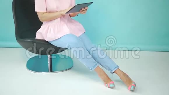 时髦的年轻女人戴着帽子喜欢在平板电脑里社交视频的预览图