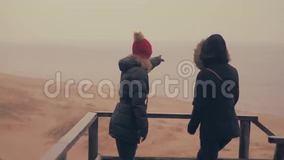 两个女孩在靠近大海的春天森林里享受雨60至24fps视频的预览图