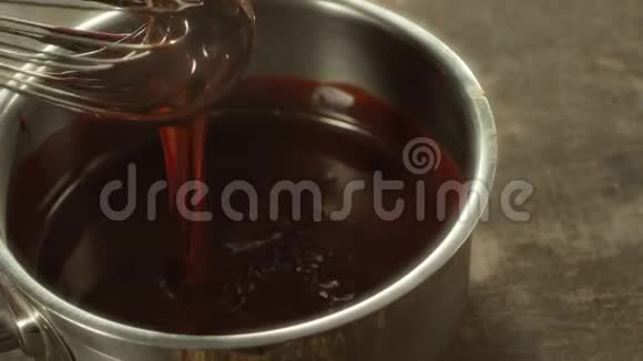 特写融化的巧克力在慢动作中混合大量的液体巧克力视频的预览图