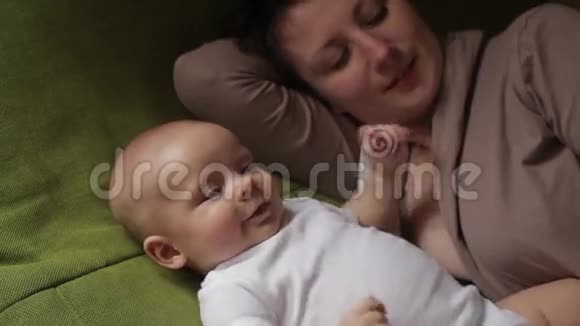 爸爸妈妈和他的小儿子在床上玩幸福家庭概念视频的预览图