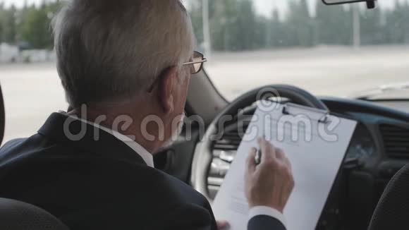 老人坐在车里正在学习文件很忙的商人视频的预览图