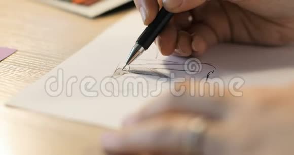 女孩在纸上画一支铅笔女时装设计师绘制草图时装设计师绘图和油漆特写视频的预览图