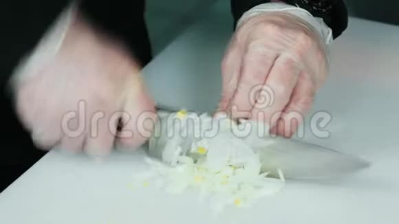 在白色切割板的特写上粉碎和切割洋葱视频的预览图